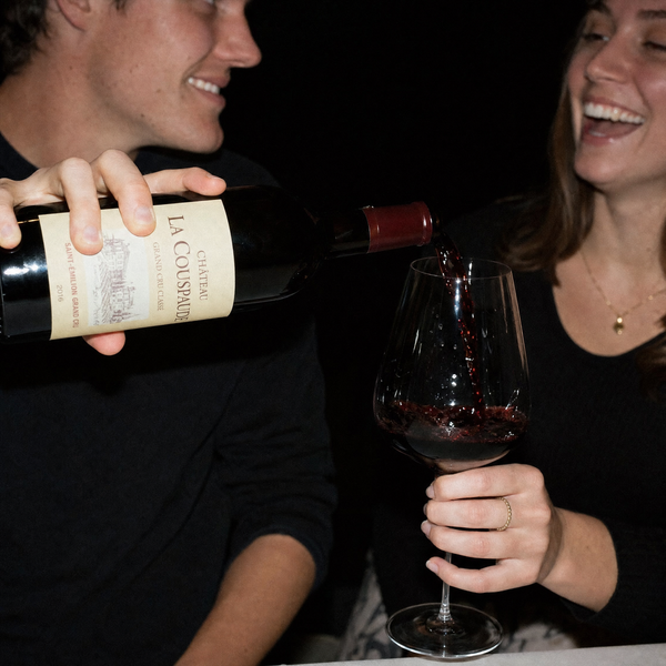 Red wine being poured at a dinner table