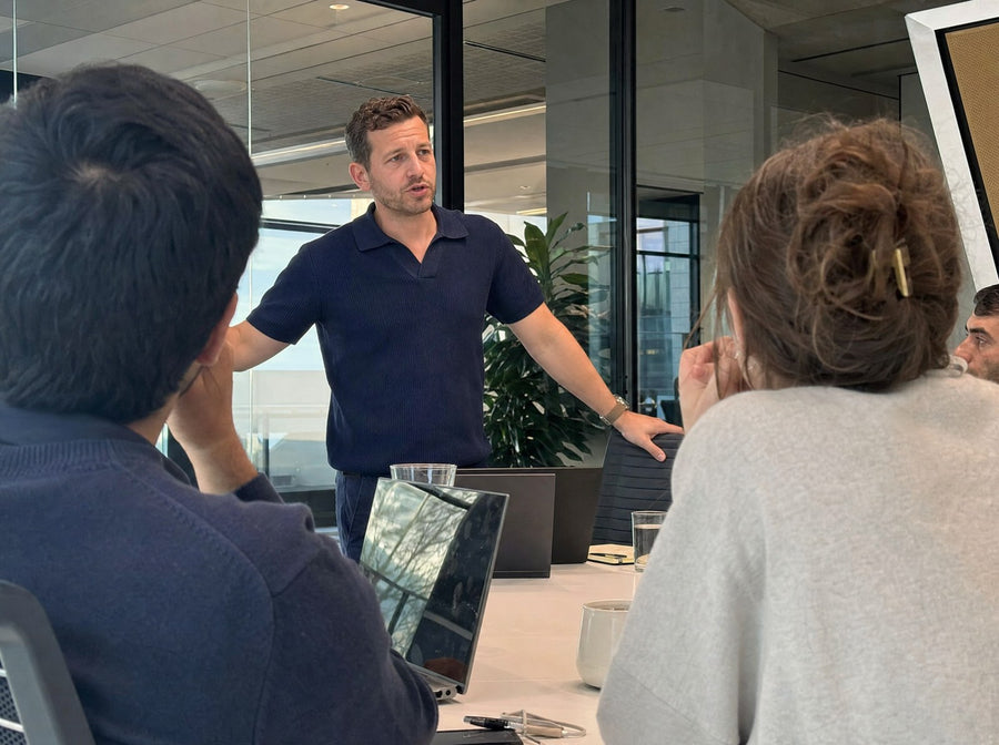 A founder leading a Monday meeting in a boardroom